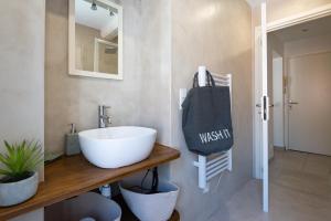 een badkamer met een witte wastafel en een spiegel bij Studio Carignan in Bandol