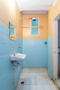 une salle de bains bleue avec lavabo et fenêtre. dans l'établissement Impala Hotel Parklands, à Nairobi