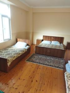 2 camas en una habitación con suelo de madera en Rey, en Nabran