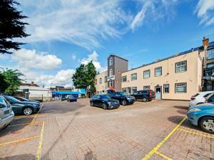 een groep auto's geparkeerd op een parkeerplaats bij OYO Bostons Manor Hotel in Greenford