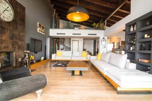 sala de estar con sofás blancos y reloj en Villa Equinox, en Ixia