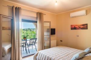 a bedroom with a bed and a balcony with a table at Villa giannis in Vitalades +52 photos