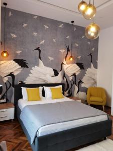ein Schlafzimmer mit einem großen Bett mit Vögeln an der Wand in der Unterkunft ZEN Apartments Oradea in Oradea