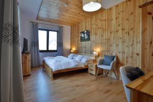a bedroom with a bed and a table and a chair at Rezort Gothal Chalupy in Donovaly