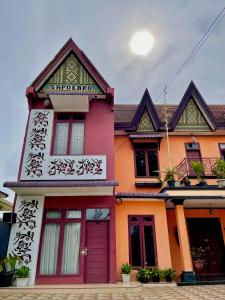 una casa colorida con una puerta roja en Sapo Karo Rest House, en Berastagi