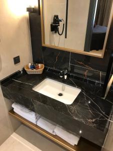 a bathroom counter with a sink and a mirror at Esila Hotel in Ankara