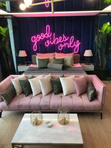 eine rosa Couch mit einem Schild, auf dem nur gute Schwingungen stehen in der Unterkunft Esila Hotel in Ankara