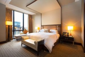 a hotel room with a large bed and a window at City Of Dreams - Nüwa Manila in Manila