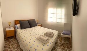 1 dormitorio con 1 cama con toallas en Flores Bliss, en Sitges