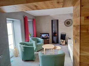 een woonkamer met groene stoelen en een tafel bij Les Gites d'Olloy - Le Beauséjour in Olloy-sur-Viroin