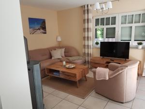 a living room with a couch and a tv at Haus Sonnenwind in Zingst