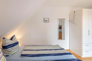 um quarto com uma cama e uma parede branca em Ferienwohnung Ingrid Heyes em Radolfzell am Bodensee