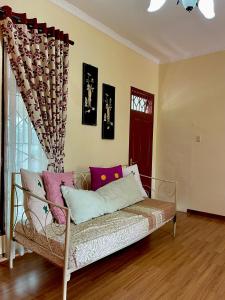 a couch in a living room with a window at Sapo Karo Rest House in Berastagi