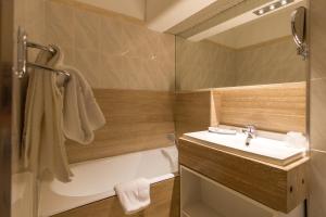 a bathroom with a tub and a sink and a bath tub at Hôtel-Résidence Le Lys in Cauterets