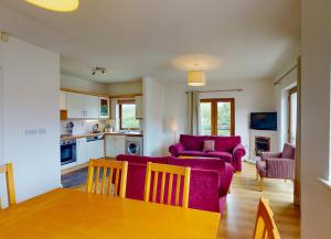 een woonkamer met een paarse bank en een tafel bij Lakeside Holiday Homes - Type B in Killaloe