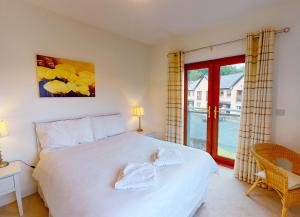 een slaapkamer met een groot wit bed en een raam bij Lakeside Holiday Homes - Type B in Killaloe