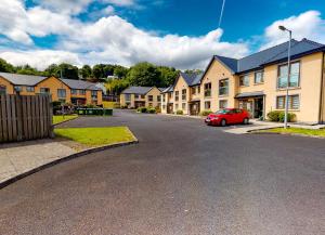 une voiture rouge garée devant une rangée de maisons dans l'établissement Lakeside Holiday Homes - Type B by Trident Holiday Homes, à Killaloe