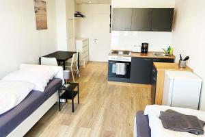 um pequeno quarto com 2 camas e uma cozinha em Work & Stay Apartment em Bitterfeld