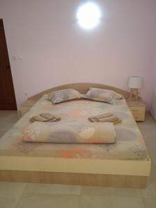 a bed in a white room with a bedvisor at СЕМЕЕН ХОТЕЛ ИЛИЕВАТА КЪЩА in Sapareva Banya