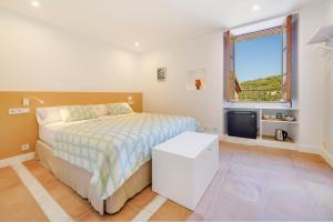 1 dormitorio con cama y ventana en Menditzu Rooms, en Biniaraix