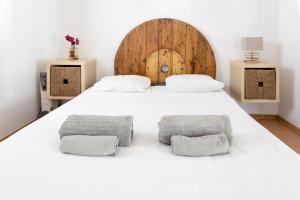 a bedroom with a large white bed with two pillows at Casa da Mata SurfHouse in Costa da Caparica