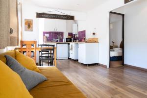 a living room with a couch and a kitchen at Casa da Mata SurfHouse in Costa da Caparica