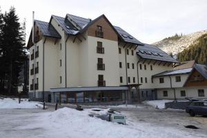 a large white building with snow on the ground at Apartamenty Lucky 188 in Belá