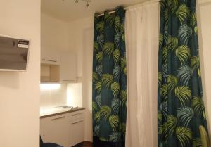 a bathroom with a shower curtain with a kitchen at Residenze Sorrentino in Bari