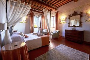 a bedroom with a bed and a table and a mirror at Villa Curina Resort in Castelnuovo Berardenga +146 photos