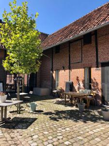 a brick building with a picnic table and a tree at Winning De Zwaen in Hasselt +61 photos