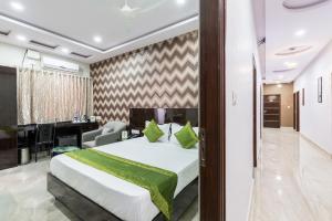 a hotel room with a bed and a desk at Treebo Trend Greenwood Premier Suites Old Airport Road in Bangalore