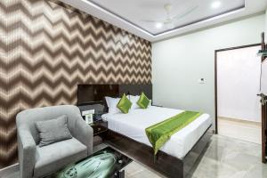 ein Schlafzimmer mit einem Bett und einem Stuhl in der Unterkunft Treebo Greenwood Premier Suites, Old Airport Road in Bangalore + 23 Fotos
