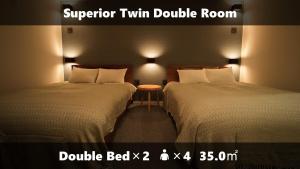 a hotel room with two beds and a table between them at Vieuno Stay Hakata 1 in Fukuoka