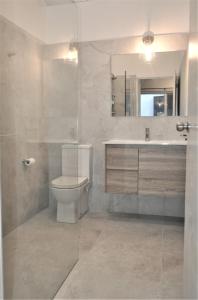 a bathroom with a toilet and a sink and a mirror at Mysa Anglesea Sleeps 7 WiFi SmartTV Cafes Shops in Anglesea
