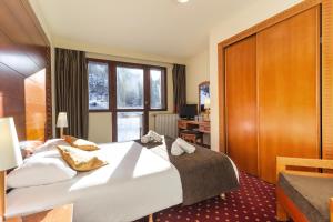 a hotel room with a large bed and a window at Hôtel La Plagne Le Terra Nova in La Plagne