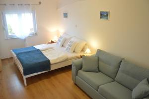 a small bedroom with a bed and a couch at Villa Dobra Holiday Apartments in Vir
