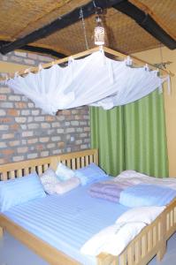 a bedroom with two beds with a canopy at Muga Eco Village in Ntungamo