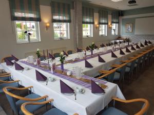 a row of tables and chairs in a room at Rosen-Hotel in Sangerhausen