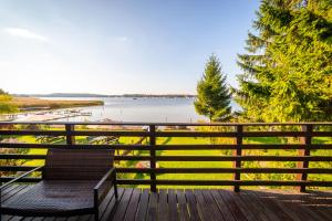 a bench on a deck with a view of the water at Domek nad samym brzegiem jeziora z prywatną "4-You" in Mikołajki