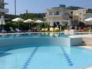 a large swimming pool in front of a building at Elpida Beach Studios in Faliraki