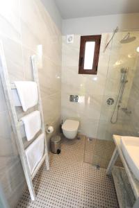 a bathroom with a toilet, sink, and shower at Castle View Bungalows in Mystras