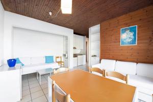 a dining room with a table and white chairs at Residence La Cava Trilocale 1d in Pognana Lario