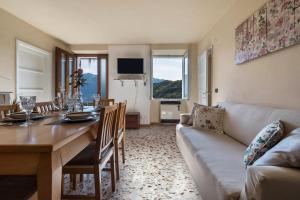 uma sala de estar com uma mesa e um sofá em Casa Vacanze Voiandes em Tremosine Sul Garda