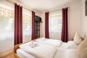 two beds in a room with red curtains at Apt Hofer Maria in Villabassa