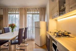 a kitchen with a white refrigerator and a table with chairs at Apt Hofer Maria in Villabassa