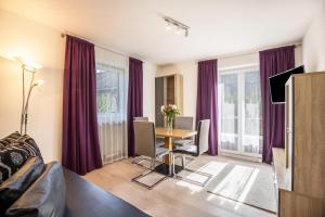 ein Wohnzimmer mit einem Tisch und lila Vorhängen in der Unterkunft Apt Hofer Elisabeth in Niederdorf