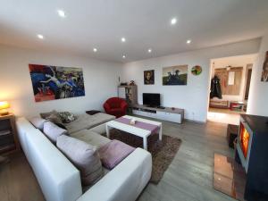 a living room with a white couch and a tv at Chalupa Margareta in Telgárt