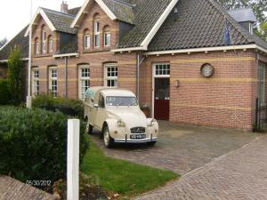 une vieille voiture garée devant une maison en briques dans l'établissement B en B 't Pekeltje, à Medemblik