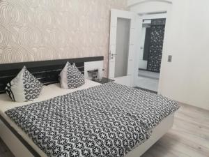 ライヒェンバッハ・イム・フォークトラントにあるHochwertige Ferienwohnung/zentrumsnahe Lage!のベッドルーム(枕付きの黒と白のベッド1台付)