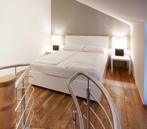 a white bed sitting next to a white wall at The Levante Rathaus Apartments in Vienna